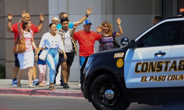 Shoppers exit with their hands up after the shooting