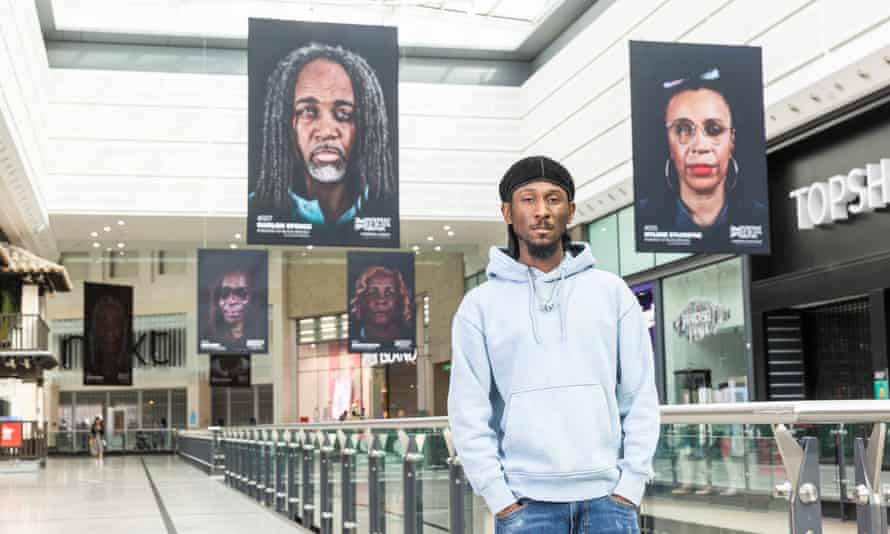 Cephas Williams with some of his photos for an exhibition at the Arndale Centre in Manchester as part of the Manchester international festival.