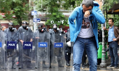 Veli Saçılık stands in front of a line of riot police after tear gas was used to disperse protesters.