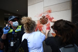 Protesters smear red dye over an emblem at the British Consulate during an anti-monarchy protest in Melbourne, Australia, 22 September 2022.