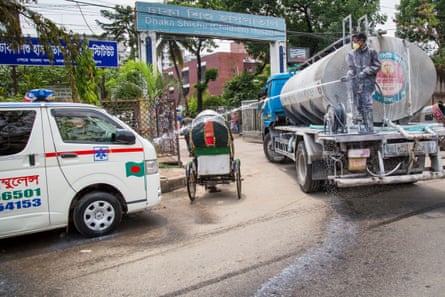 City corporation workers spray disinfectant on the hospital and nearby roads.