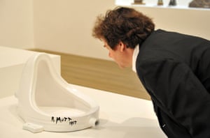 Un visitante mira en la fuente (1917) de Marcel Duchamp (1887-1968) - el urinario público que Duchamp transformó en una obra de arte y es visto como el paradigma del readymade.