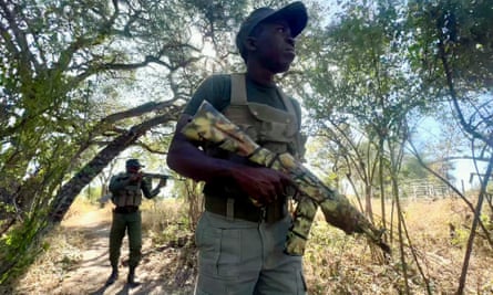 Cobra rangers Cedric Moyo, rear, and Nyoni Qabukani on patrol around the fenced rhino reserve in Zimbabwe