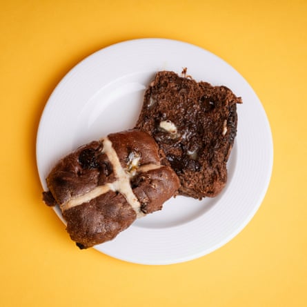 A Lidl Deluxe triple chocolate hot cross bun, sliced, toasted and buttered, on a white plate