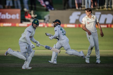 Bavuma e Rickelton, da África do Sul, correm entre os postigos enquanto Pat Cummins observa