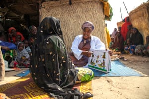 Amina Shallangwa, a Unicef-supported midwife, talks to a pregnant woman about good hygiene practices at Muna Garage camp for internally displaced people in Nigeria