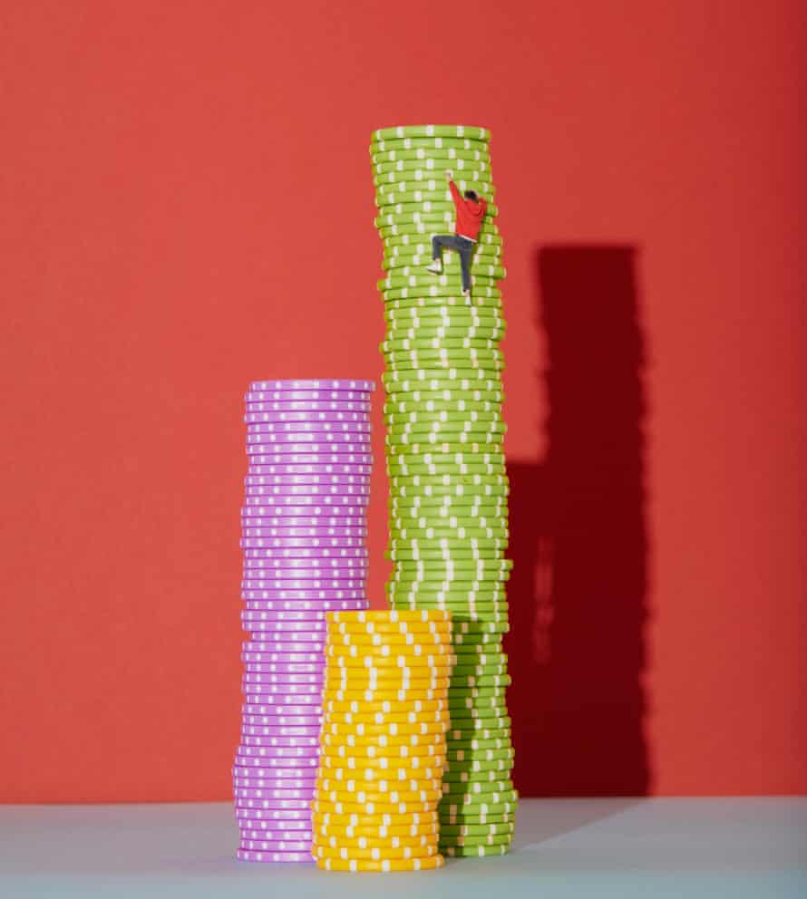 A tiny man climbing up a stack of poker chips
