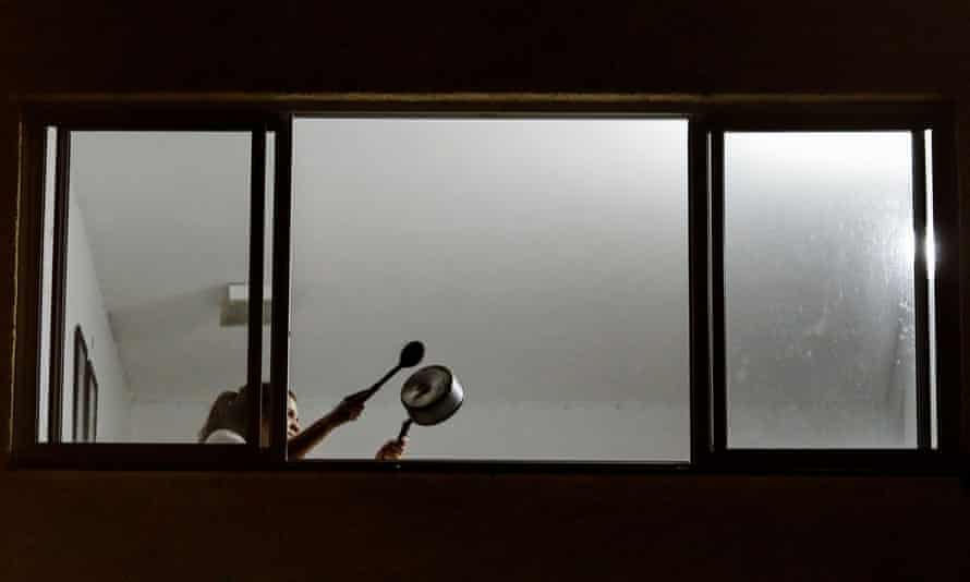 A person beats a pot from a window to protest against Brazil’s President Jair Bolsonaro