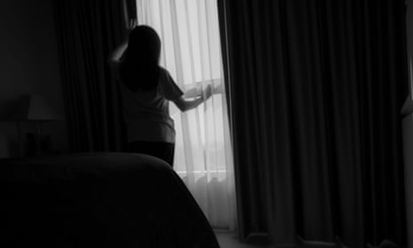 Woman in silhouette looking out a window