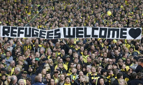 Borussia Dortmund supporters hold a banner showing their support for refugees.