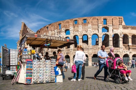 Superb urban fabric … tourists pass the Colosseum in Rome.