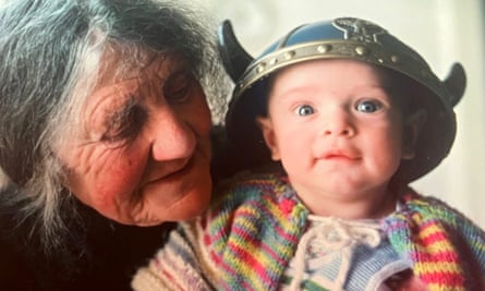An older Nan Shepherd holding a little boy who is wearing a Viking helmet