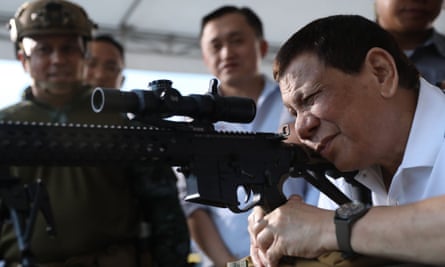 President Duterte fires a rifle at a ceremony