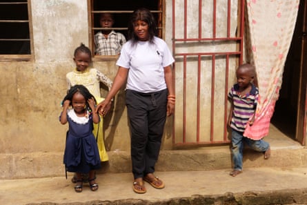 Bangala stands in front of her home in Kailo with four of her eight children