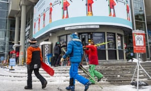 Skiers pass a social distancing sign