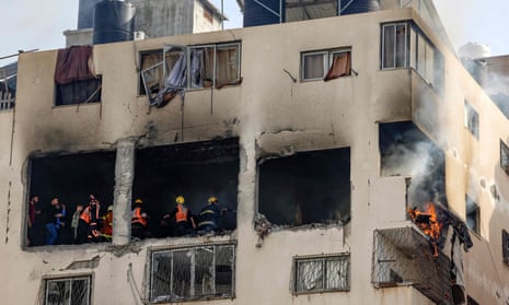 Palestinian civil defence members battle a fire in an apartment after it was targeted by Israel in Gaza City