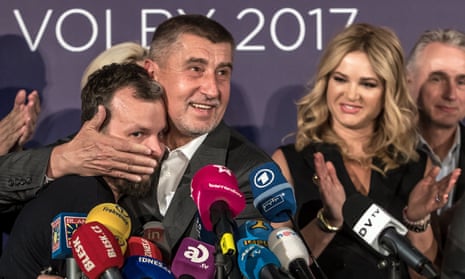Andrej Babiš embraces a colleague at a press conference in Prague