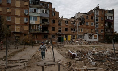A woman walks in front of her heavily damaged apartment block in Mykolaiv, southern Ukraine, after a Russian missile attack