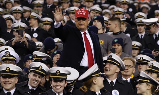 Donald Trump waves as he sits with Navy midshipmen in Philadelphia.