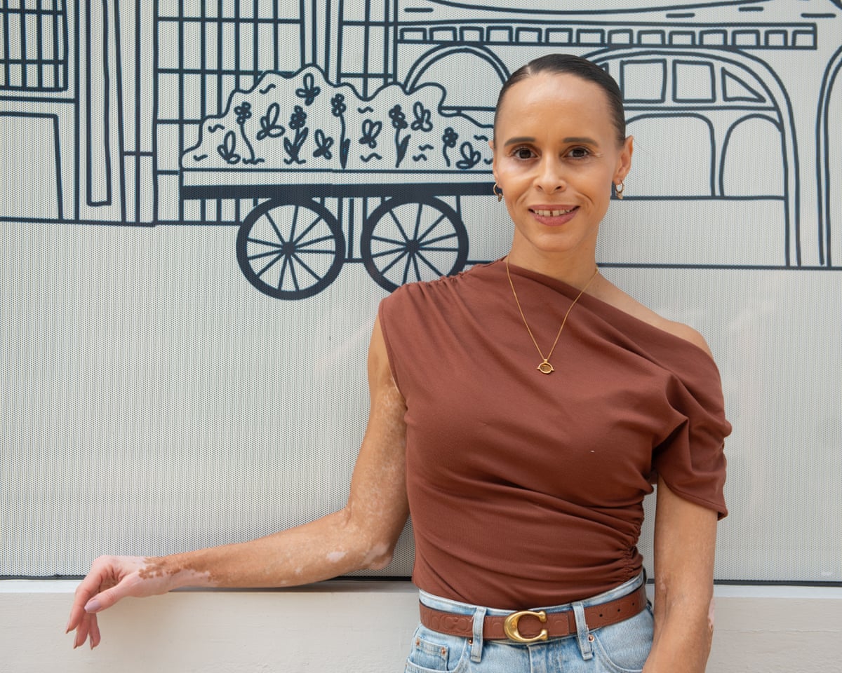 Natalie stands in front of a wall mural