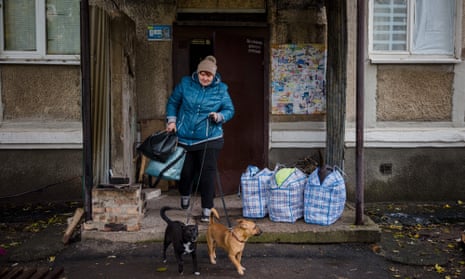 A woman brings out her two dogs to evacuate from the town of Bakhmut in Donetsk region, on 25 October.
