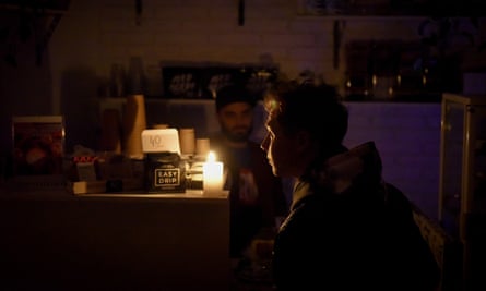 Un barista habla con un cliente en un café durante un corte de energía en Kyiv.