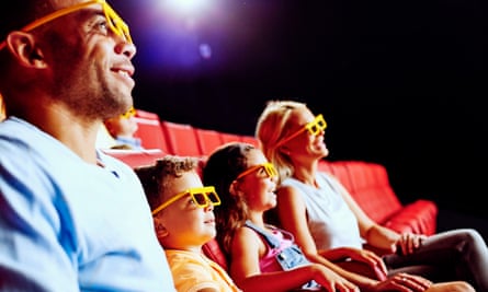 Family of four in the 4D cinema, and wearing viewing glasses, at Legoland Discovery Centre Birmingham, UK.