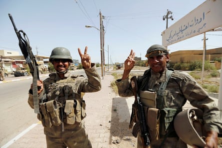 Iraqi soldiers gesture in centre of Falluja, Iraq on 17 June 2016.