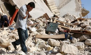 A Syrian man reacts as rescuers look for victims under the rubble of a collapsed building following a reported airstrike on the rebel-held neighbourhood of Sakhur in Aleppo on 19 July.