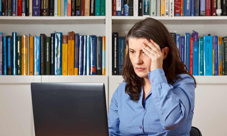 Mature woman in front of a computer in the office pressing a hand at her forehead, headache, migraine, stressHC6PRT Mature woman in front of a computer in the office pressing a hand at her forehead, headache, migraine, stress
