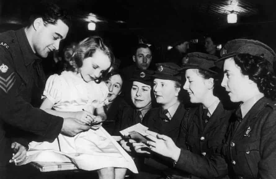 Petula Clark as a child, signing autographs for soldiers in 1940.