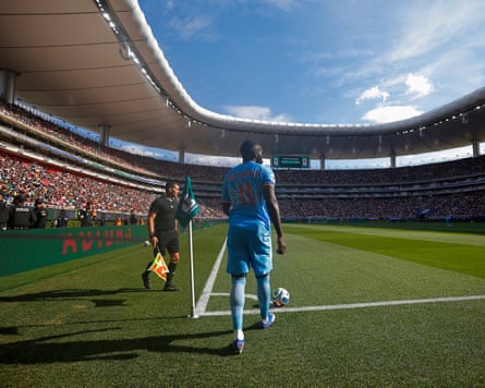 A player prepares to kick a ball from the corner flag during a match at Estadio Akron.