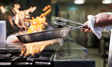 Closeup of chefs hands holding a saute pan
