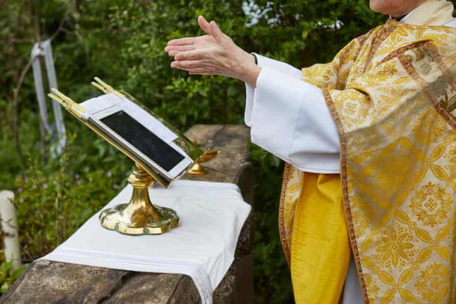 Rev Helen Chandler conducts Sunday Service in her garden outside St Peter and St John, an Anglican church near Lowestoft, Suffolk, May 2020