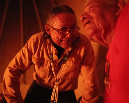 Jonus Yazzie, left, speaks with another man during a peyote ceremony