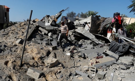 Palestinians walk over rubble at the site where a girl was killed in Israeli strikes on a house in Khan Younis in the southern Gaza Strip.
