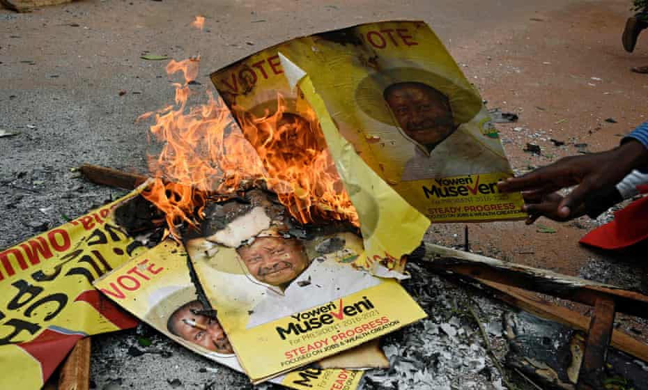 Supporters of the opposition leader Kizza Besigye burn posters of President Yoweri Museveni in Kampala, two days before the Ugandan elections