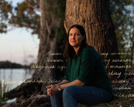 Ella Archibald-Binge sits under a tree beside the lagoon