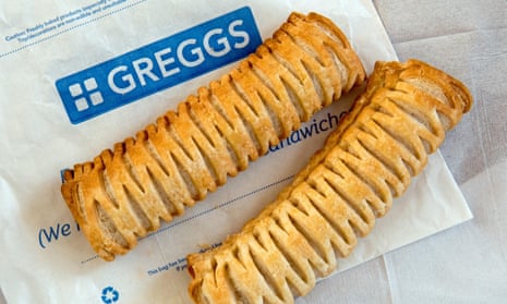 Two Greggs vegan sausage rolls on a paper bag with paper napkins behind.