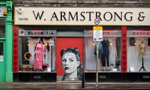 Armstrongs vintage clothing store with the shutter down revealing a retro protrait of a young woman.M4C074 Armstrongs vintage clothing store with the shutter down revealing a retro protrait of a young woman.