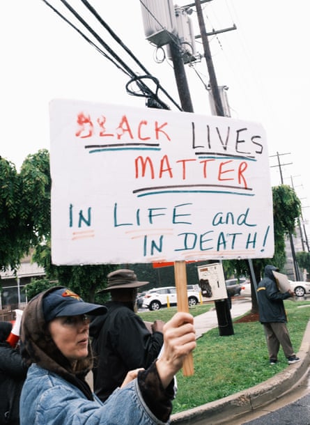 A women holding a sign saying ‘Black Lives Matter in life and in death’
