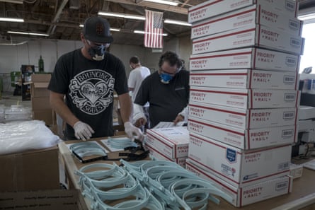 Workers pack orders for face shields at Mask &amp; Shield, a division of Monster City Studios, in Fresno, California, in May.