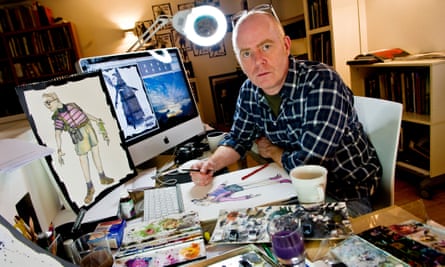 Set and costumer designer Lez Brotherston at work at a desk and computer with drawings around him.