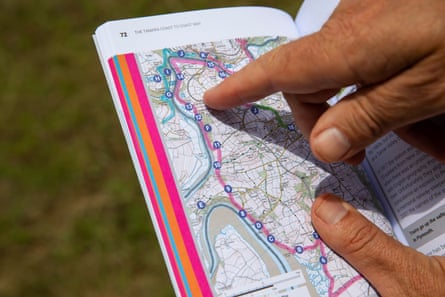 A page of a guidebook with a man’s finger pointing out a trail