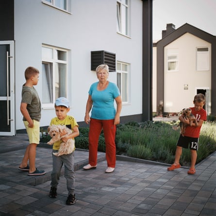 An older woman outside a house with three children