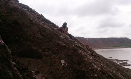 Child digging for cobalt on the industrial mine hill adjacent to Lake Malo in Democratic Republic of Congo.