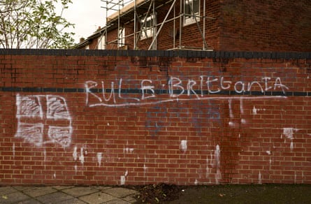 Graffiti on a red-brick wall reading RULE BRITTANIA