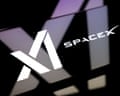 The xAI and SpaceX logos on a smartphone screen placed on a reflective surface on to which the xAI logo is projected.