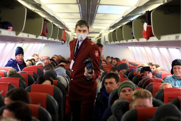 A Russian official uses a thermal imaging device to conduct a temperature check of passengers arriving at Krasnoyarsk airport on a plane from Vietnam.