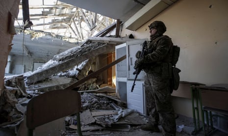 A Ukrainian serviceman is seen in a destroyed school building at a frontline in the Donetsk region, Ukraine